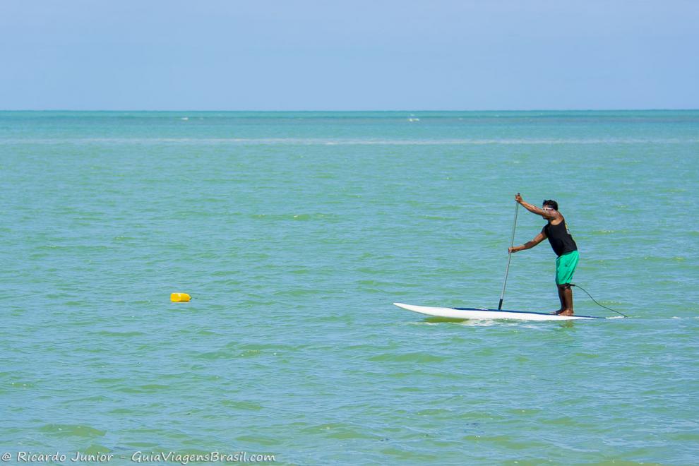 Imagem surfista praticando stand up paddle na Praia do Mutá.